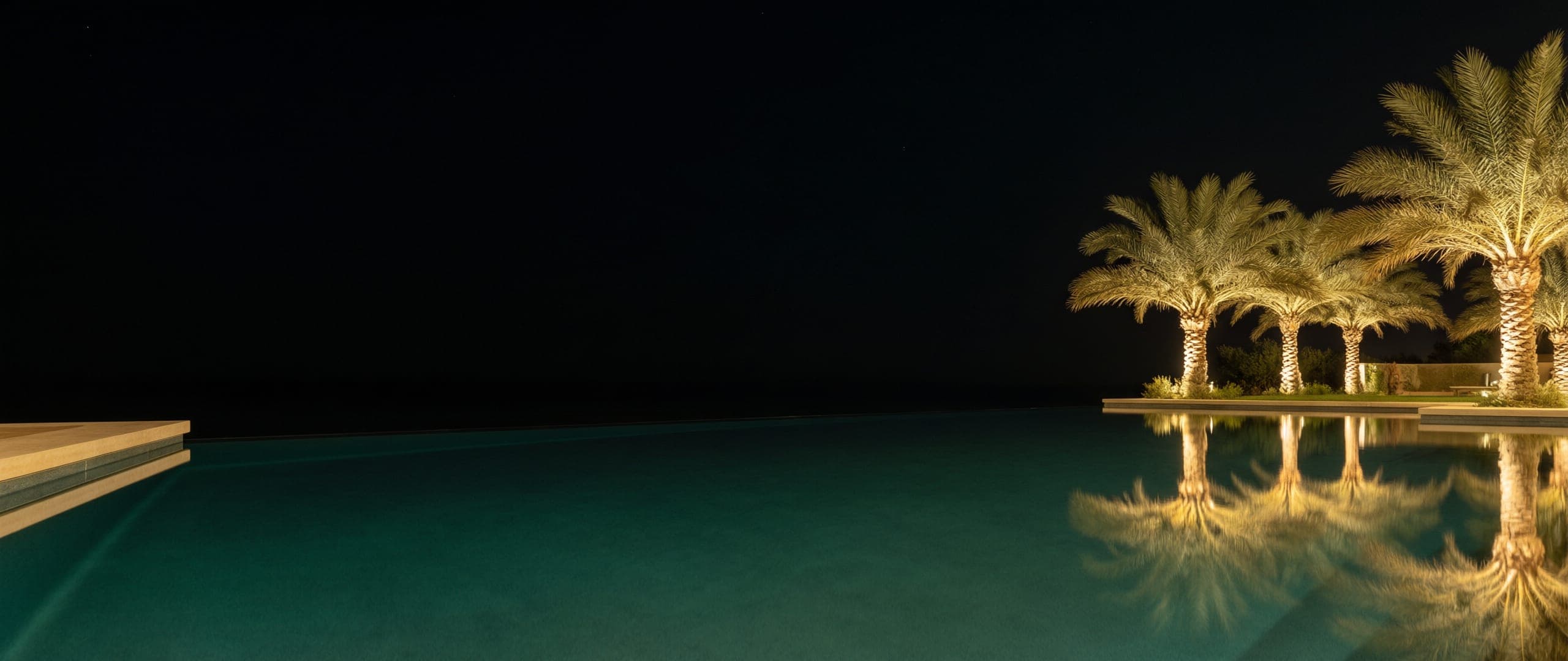 Finished luxury swimming pool at night with warm reflections
